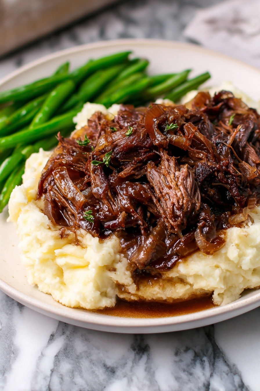 The dish shows three layers on a white plate with a striped edge. The bottom layer is creamy mashed potatoes, soft with a smooth texture and light off-white color. On top of the potatoes, there is a thick layer of shredded dark brown beef with a slightly shiny and juicy look, mixed with bits of cooked onions. To the side of these layers, there are bright green cooked green beans, adding a fresh, crisp texture and vibrant color that contrasts the others. The plate sits on a white marbled textured surface. photo taken with an iphone --ar 2:3 --v 7