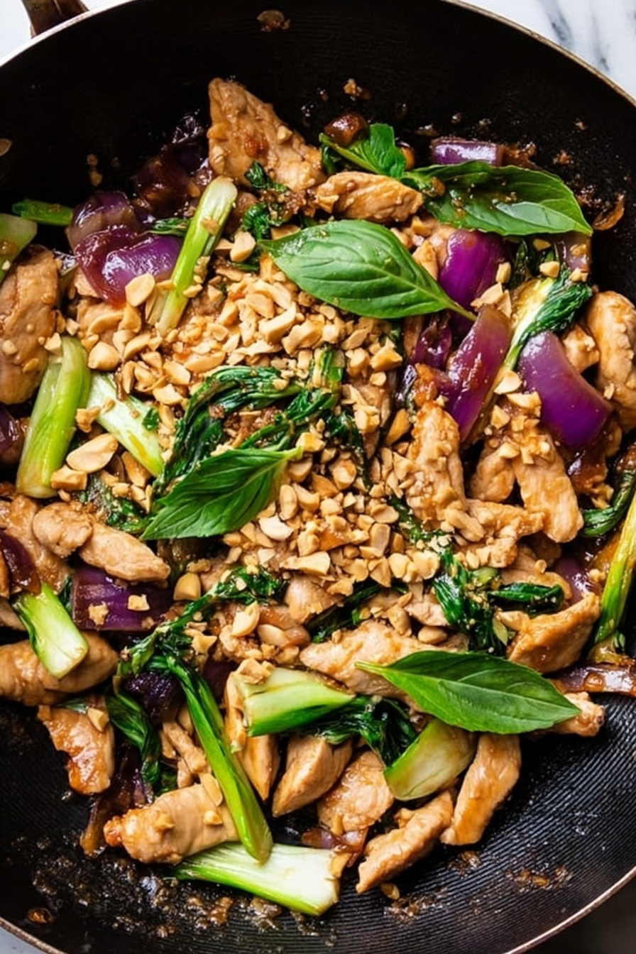 The dish shows strips of cooked light brown chicken placed on a black pan with a rough texture. Bright green bok choy pieces with white stems are scattered throughout the pan. There are chunks of soft purple-red onions mixed in, adding a pop of color. Small pale brown crushed peanuts are sprinkled all over the top. Fresh green basil leaves are placed around, adding a fresh look. The scene is set on a white marbled surface. photo taken with an iphone --ar 2:3 --v 7