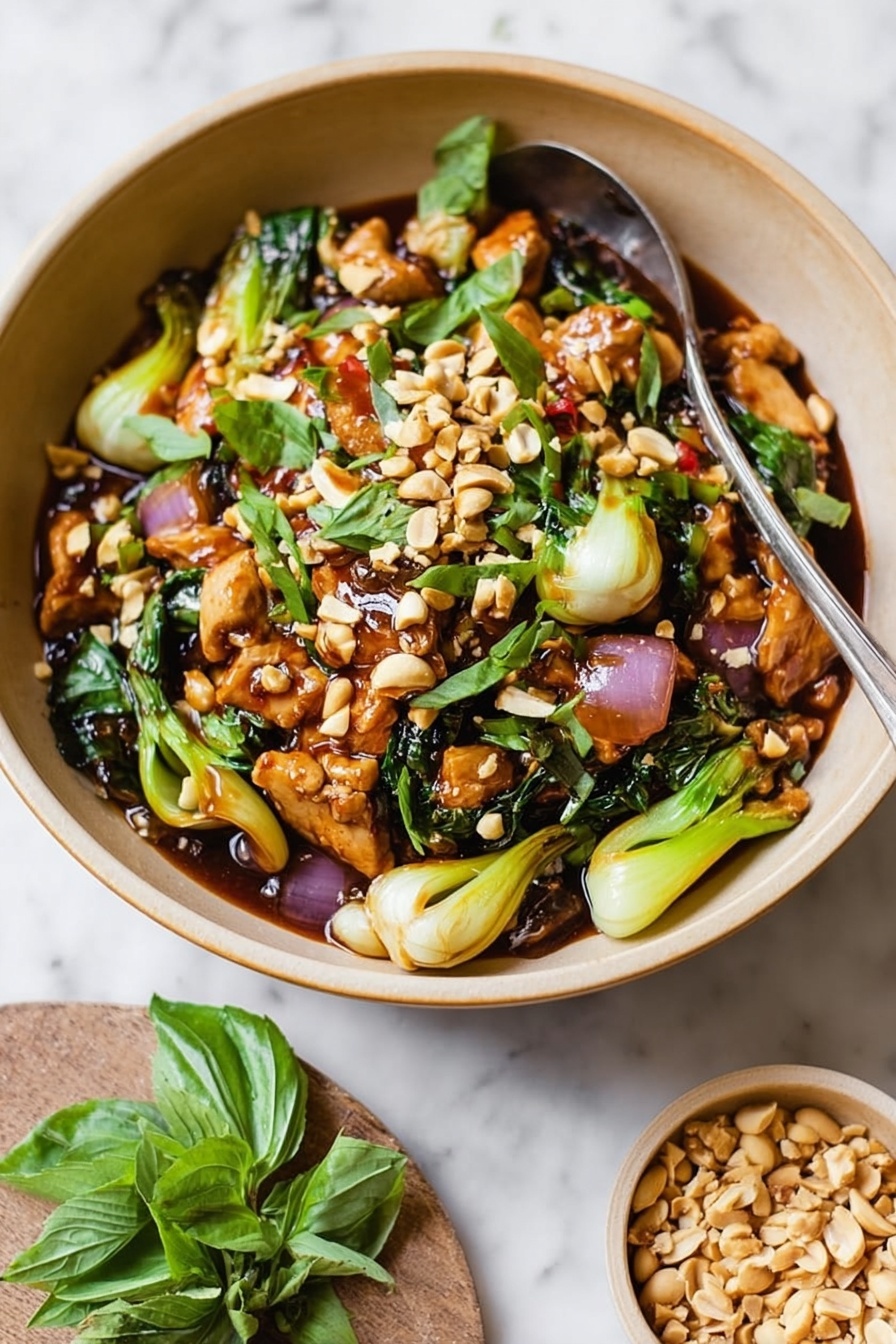 A beige bowl filled with a colorful stir-fry dish, showing about four main layers: the bottom layer is a mix of light brown sauce and green vegetables like bok choy with a soft texture, the second layer has thin slices of light brown cooked chicken, the third layer includes chunks of red onion and green leafy herbs scattered around, and the top layer is sprinkled with crunchy chopped light tan peanuts and fresh green basil leaves. There is a spoon in the bowl and a small white bowl with extra peanuts next to it, all placed on a white marbled surface with some loose green basil leaves around. Photo taken with an iphone --ar 2:3 --v 7
