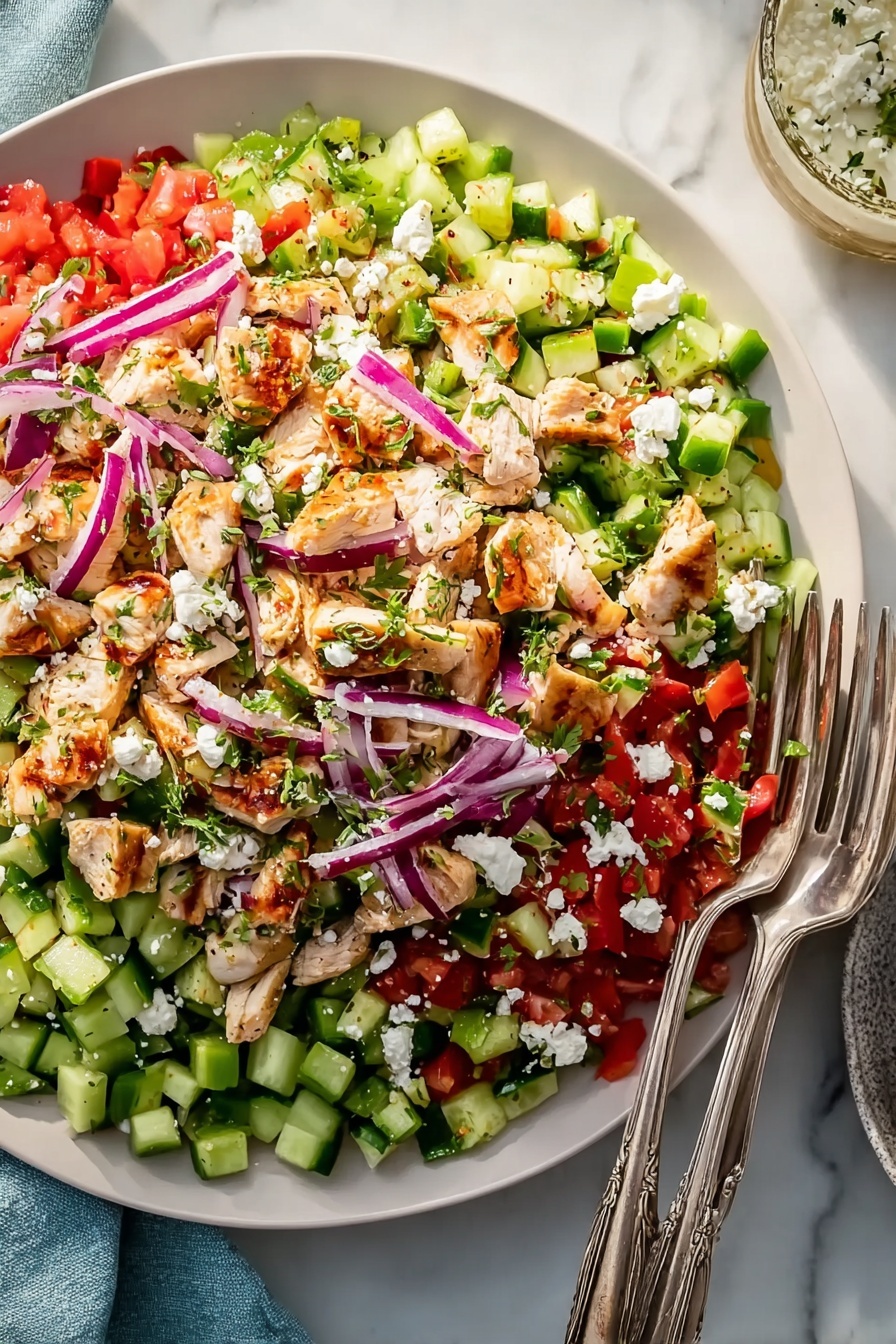 A large, shallow white plate is filled with a vibrant salad, showing about five layers. The bottom layer features small green cucumber pieces and bright red chopped tomatoes. On top of that are light brown grilled chicken chunks scattered unevenly, mixed with slim, curved slices of purple onion. Fresh green bell pepper pieces are spread across, followed by a sprinkling of white crumbled cheese. The salad looks fresh and colorful, with two silver forks resting on the right side of the plate, all set on a white marbled surface. photo taken with an iphone --ar 2:3 --v 7