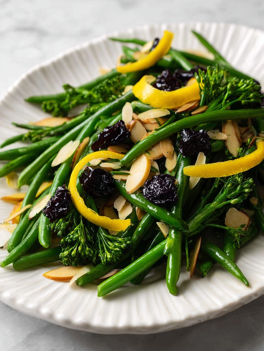 The image shows a dish of bright green green beans and broccolini layered on a white plate with a scalloped edge. On top, there are thinly sliced toasted almond flakes scattered around, along with small dark dried berries. Bright yellow strips of citrus peel are placed evenly across the vegetables, adding color contrast. To the right side of the plate, an ornate silver fork and spoon rest partially under the greens. The plate is set on a white marbled surface photo taken with an iphone --ar 2:3 --v 7