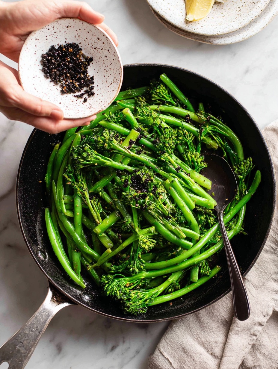 A close-up of a silver pan with bright green broccolini and green beans inside, showing fresh and shiny textures. On the right side, a woman's hand holds a white speckled small plate tilted, sprinkling small dark red or black lentils into the pan. A black silicone spatula rests inside the pan, touching the vegetables. The background is a white marbled surface, creating a clean and soft setting. Photo taken with an iphone --ar 2:3 --v 7