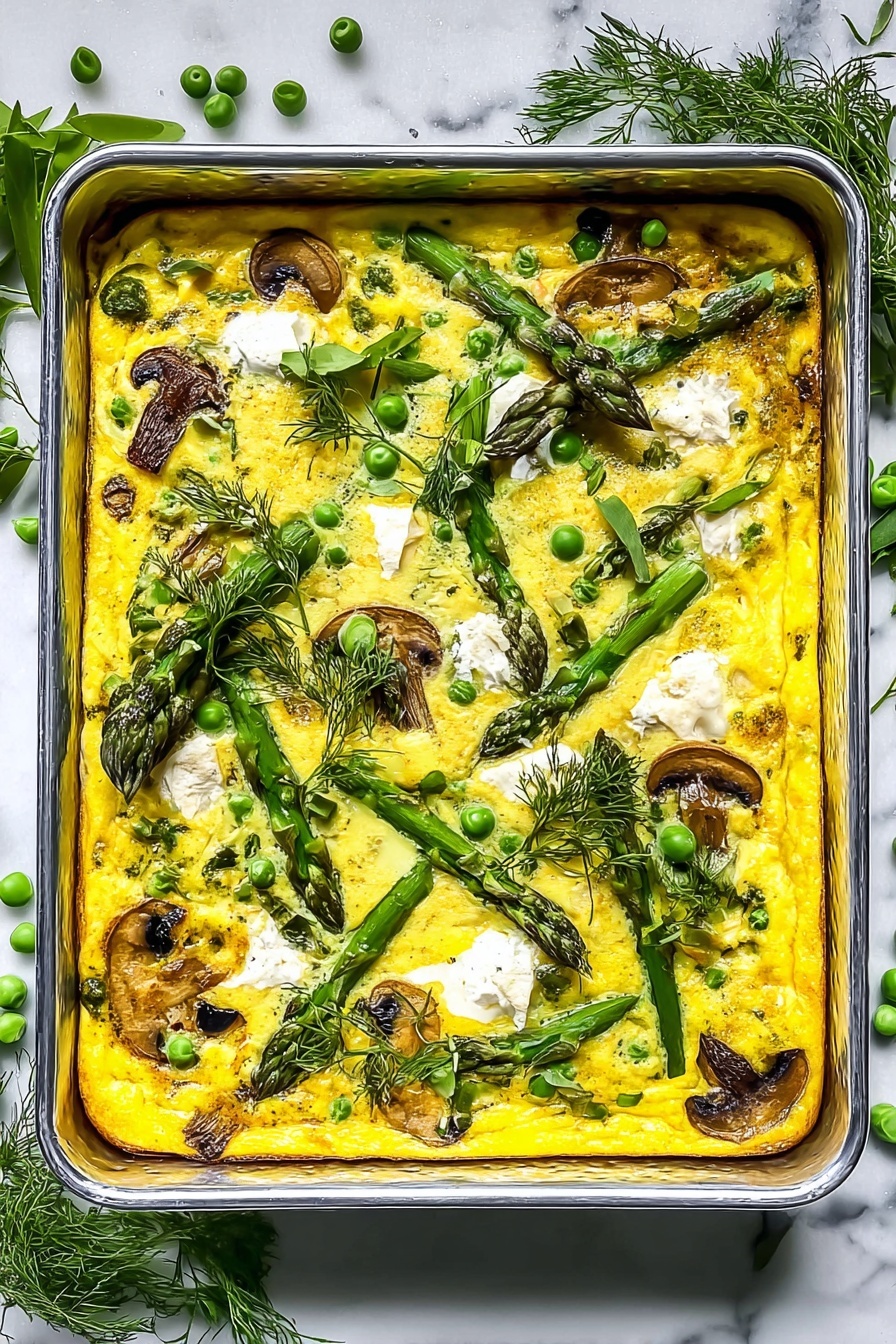 A rectangular metal baking tray filled with a yellow baked egg dish, showing one thick layer of cooked eggs mixed with peas, mushrooms, and green asparagus pieces scattered throughout. Small white dollops of soft cheese are evenly spread on top, with fresh green herbs like parsley and dill placed both inside the dish and as decoration on the edges. The tray rests on a white marbled textured surface with soft natural light casting bright highlights and shadows. Photo taken with an iphone --ar 2:3 --v 7