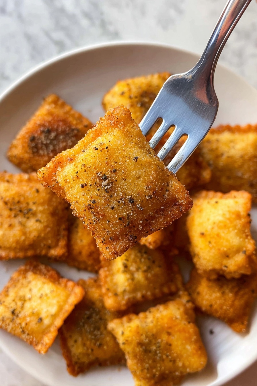 A close-up view shows a silver fork holding one square, golden brown ravioli with a crispy, herb-speckled coating. Below, a white plate holds about ten more ravioli pieces with the same crunchy texture and color, arranged randomly. The background features a dark, speckled granite surface. The lighting highlights the crispy edges and the slight unevenness of the coated ravioli. photo taken with an iphone --ar 2:3 --v 7