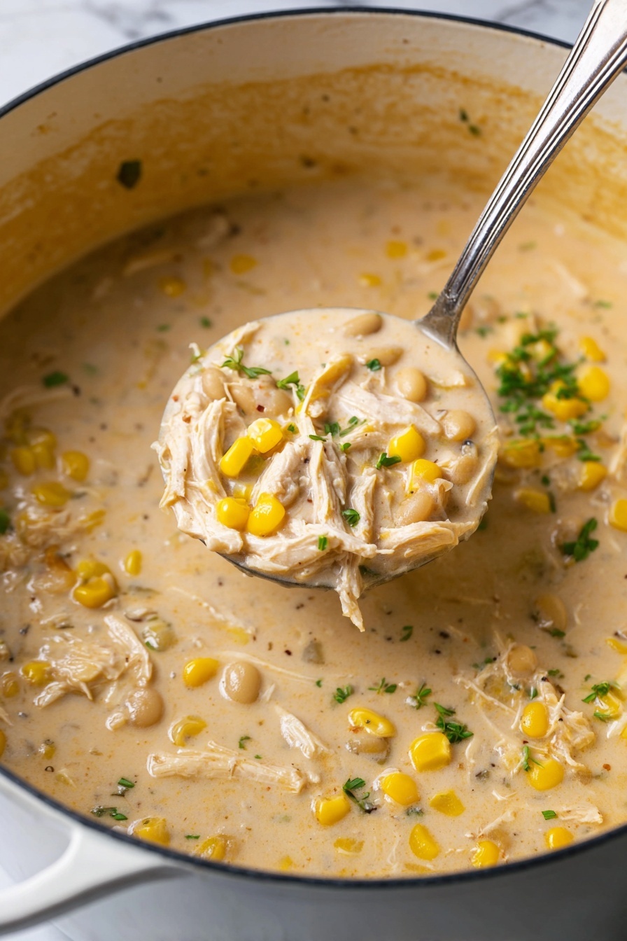 A close-up image of a thick creamy soup in a white pot, with yellow corn kernels, white beans, shredded pale chicken pieces, and small green herb leaves scattered throughout the light beige soup base. A silver ladle filled with a portion of the soup is held above the pot, showing the chunky texture with visible layers of chicken, corn, beans, and herbs, all within the creamy broth. The background is a white marbled texture. photo taken with an iphone --ar 2:3 --v 7